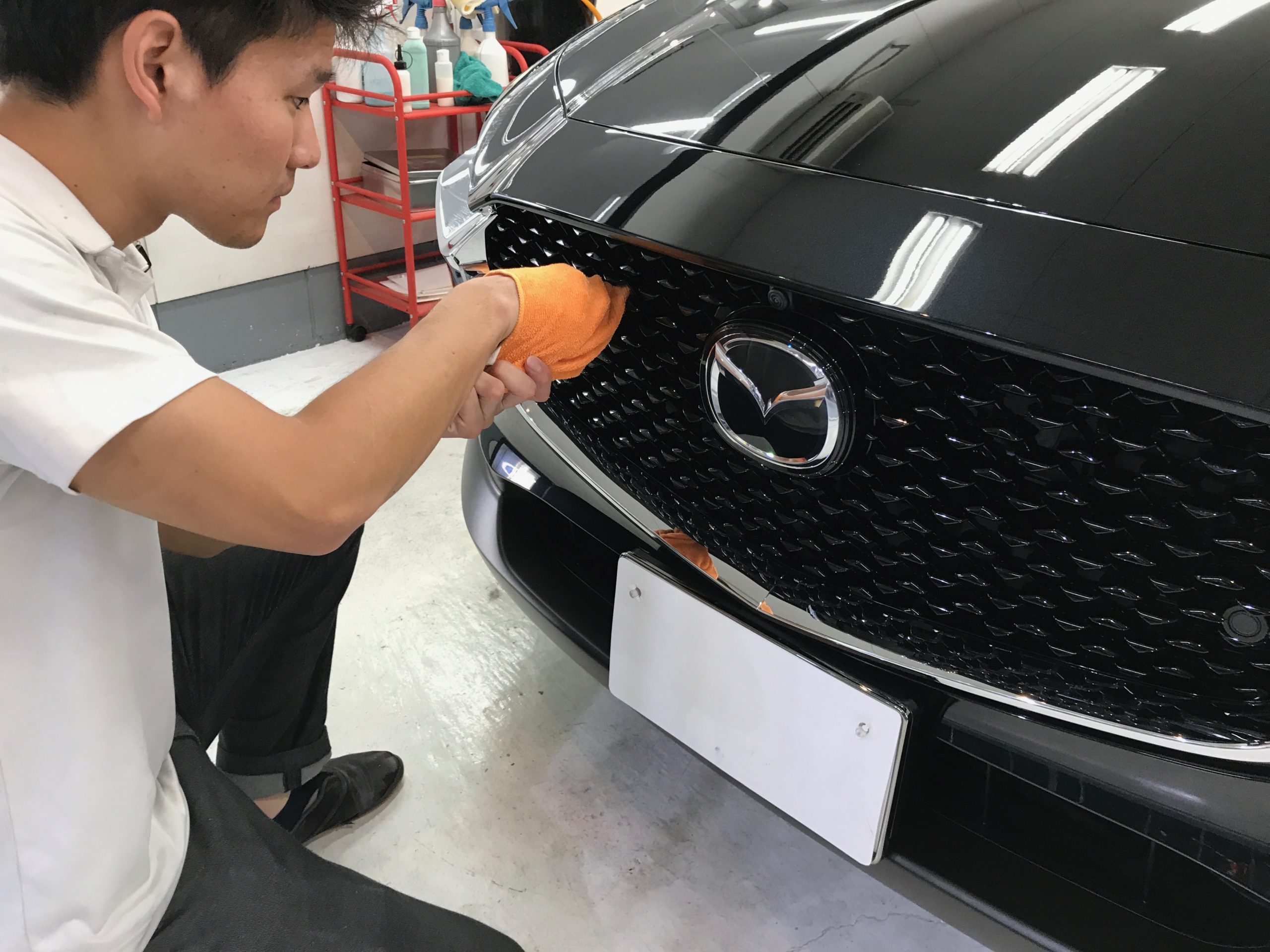 マツダ・CX-30の仕上げ作業：グリル部分をキレイに拭いていく