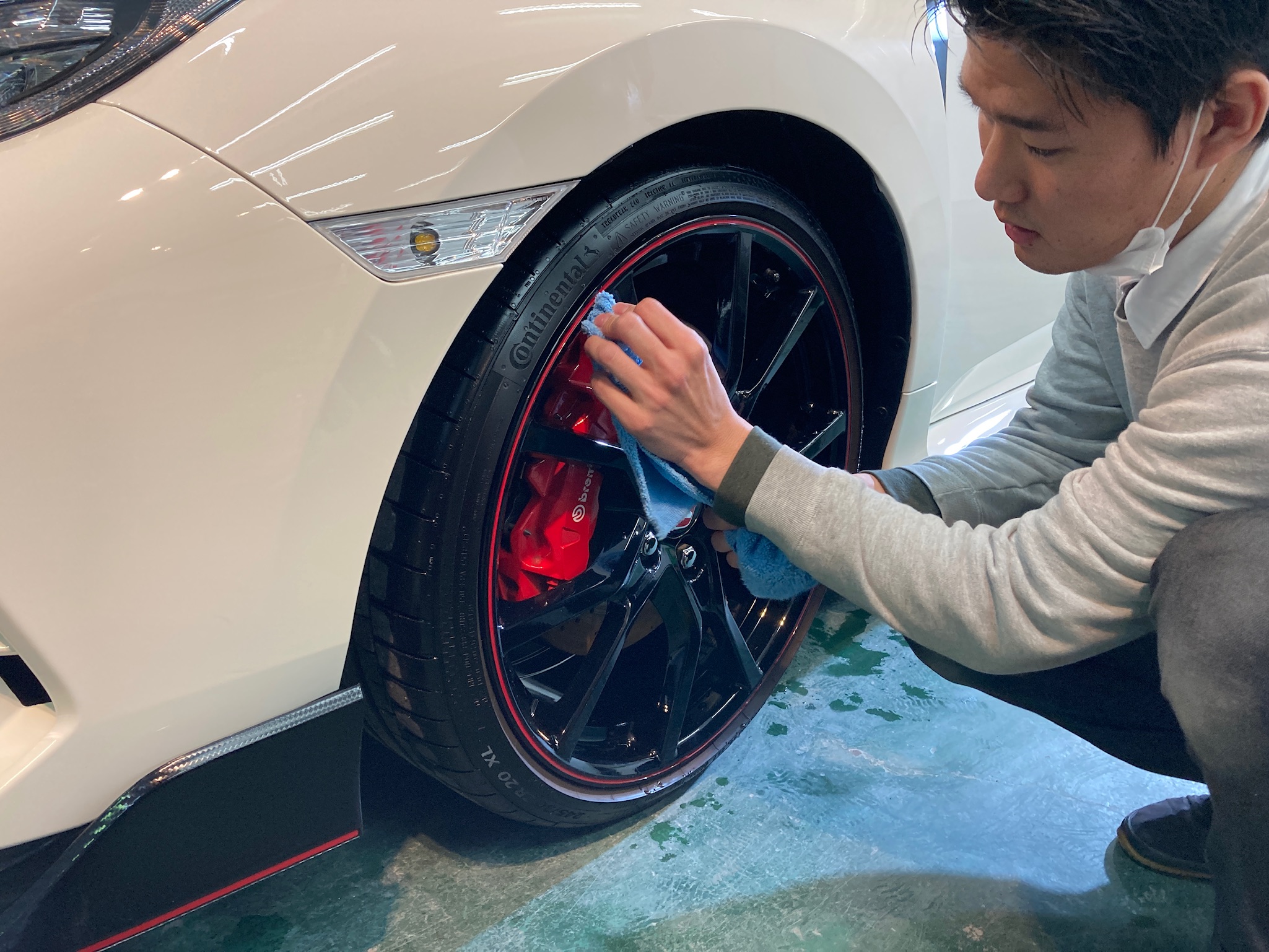 ホンダ・シビックの仕上げ作業：ホイールを拭いてキレイにしている様子