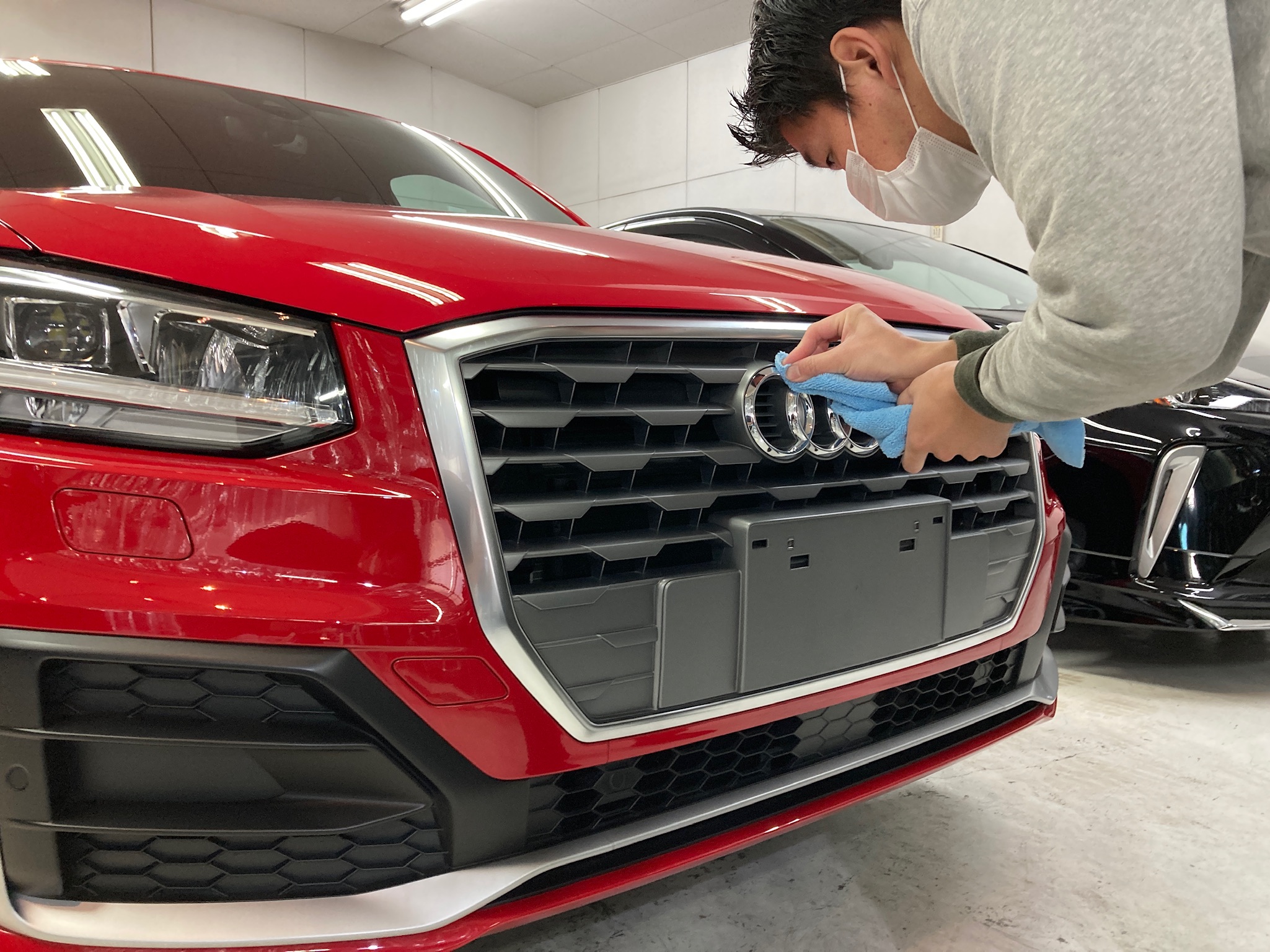 アウディ・Q2の仕上げ作業：エンブレムの汚れを取り除いている様子