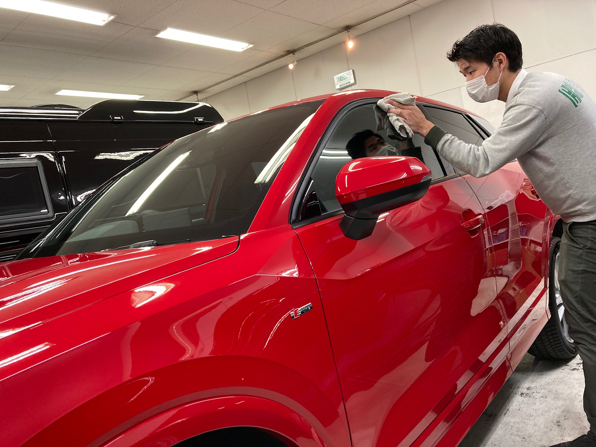 アウディ・Q2の仕上げ作業：窓をキレイに拭いている様子