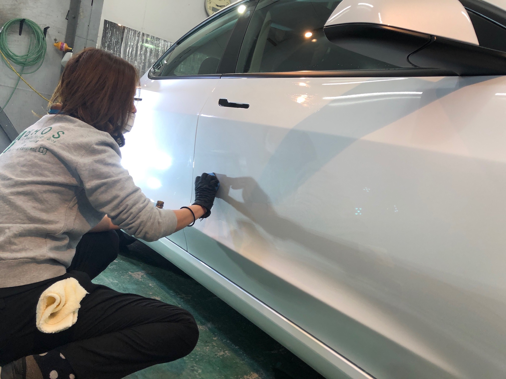 テスラ・モデル３の仕上げ作業：パネル分けしながらコーティング剤を塗布していく