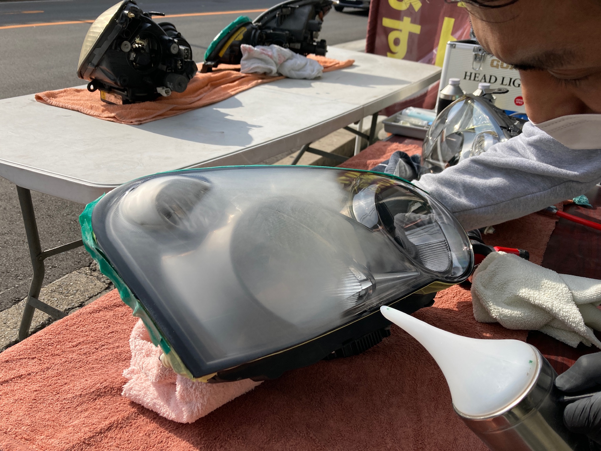 持ち込みヘッドライトの黄ばみ取り工程：蒸着作業を行う