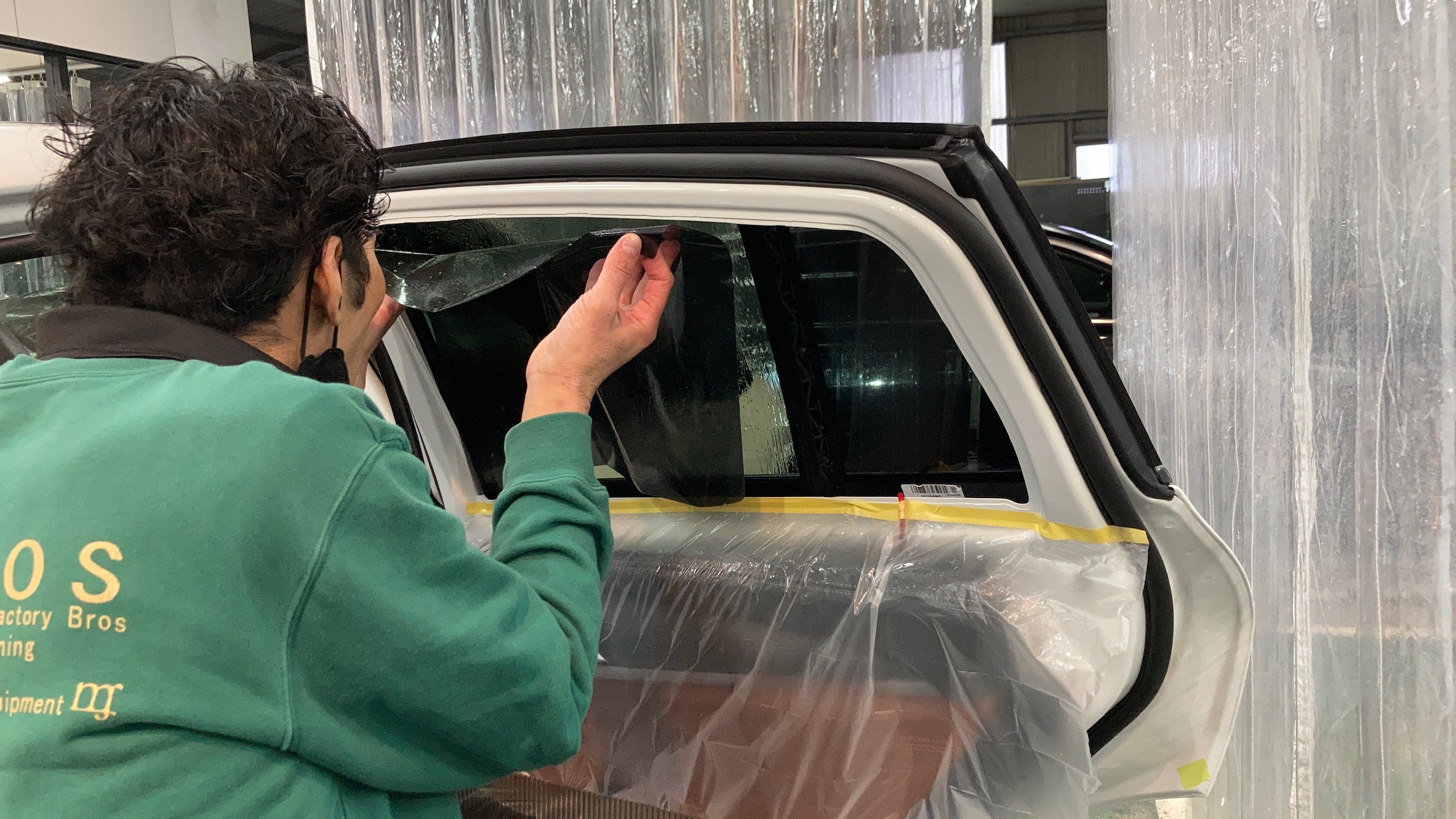 BMW・X4のカーフィルム施工工程：リアドア烏にフィルムを貼っている様子