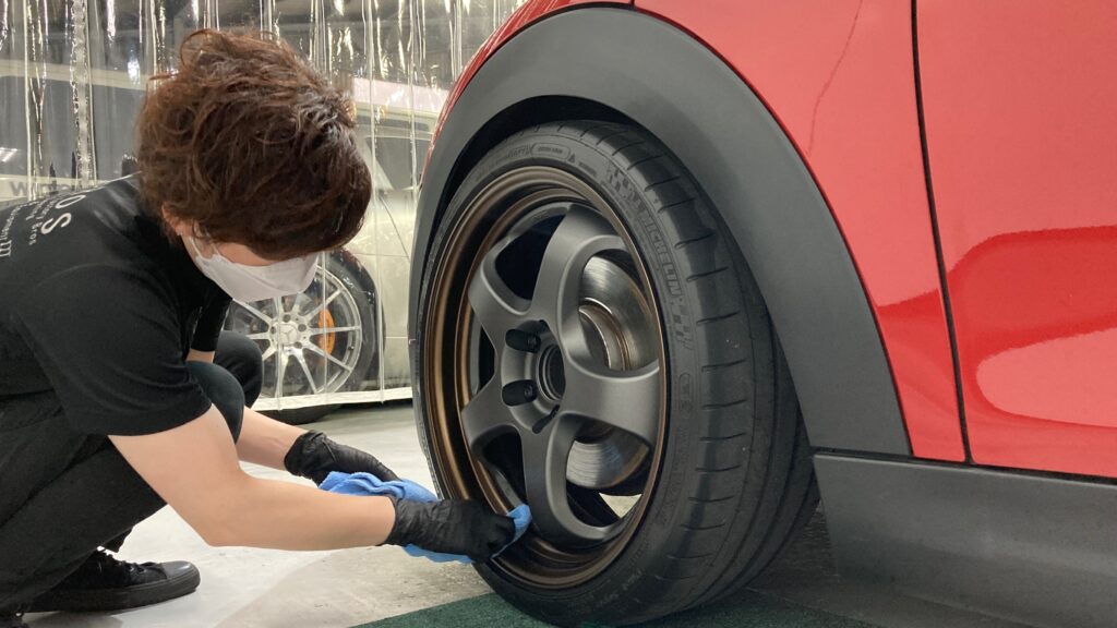 MINI・３ドアの仕上げ処理工程：ホイールを拭いてキレイにしている様子