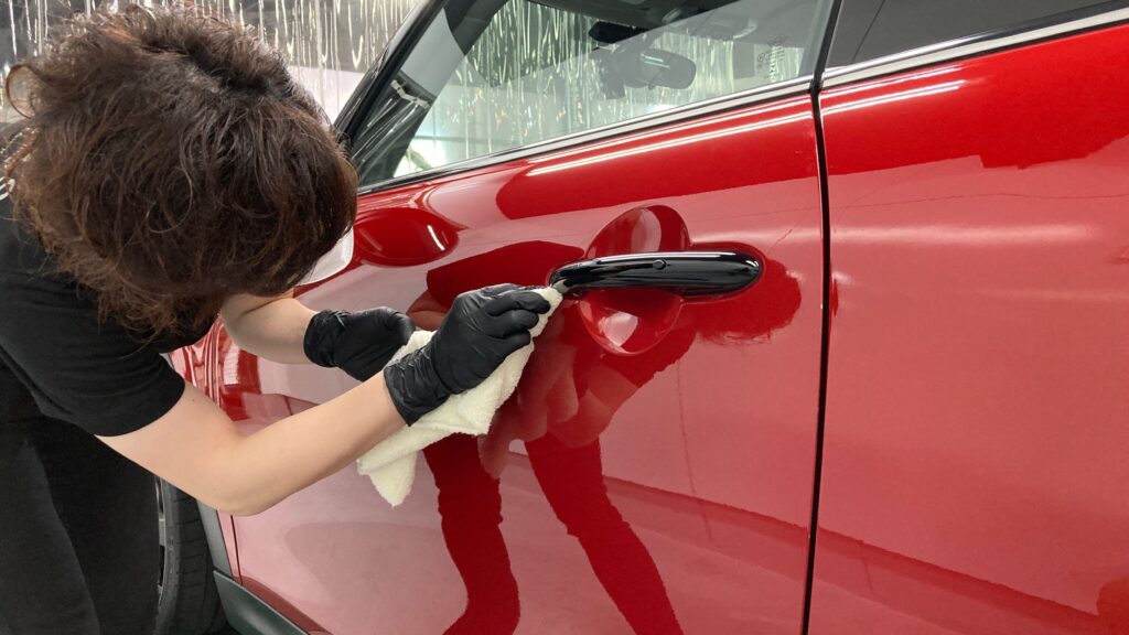 MINI・３ドアの仕上げ処理工程：細かい隙間の汚れを拭いている様子