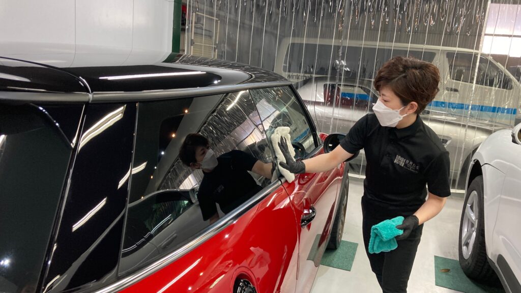 MINI・３ドアの仕上げ処理工程：窓を拭いてキレイにしている様子