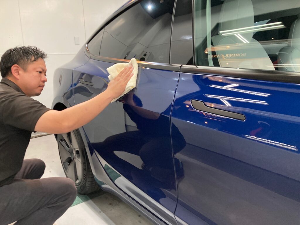 テスラ・モデル３のクラスM施工：仕上げ作業工程：コーティング剤塗布後、レベリングしている様子