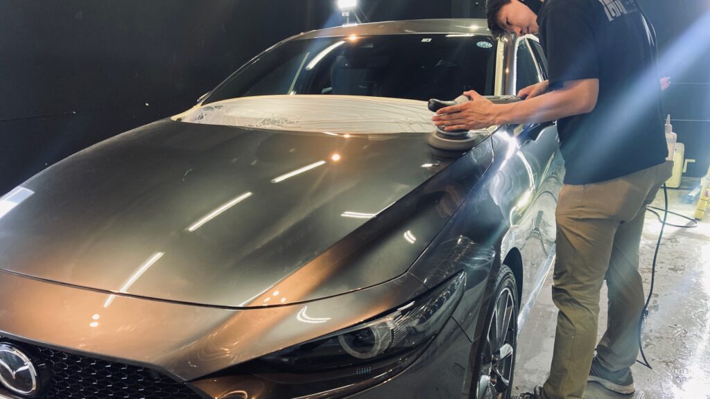 マツダ・MAZDA3：クラスM施工：下地処理工程：羊毛バフでボンネットを研磨している様子