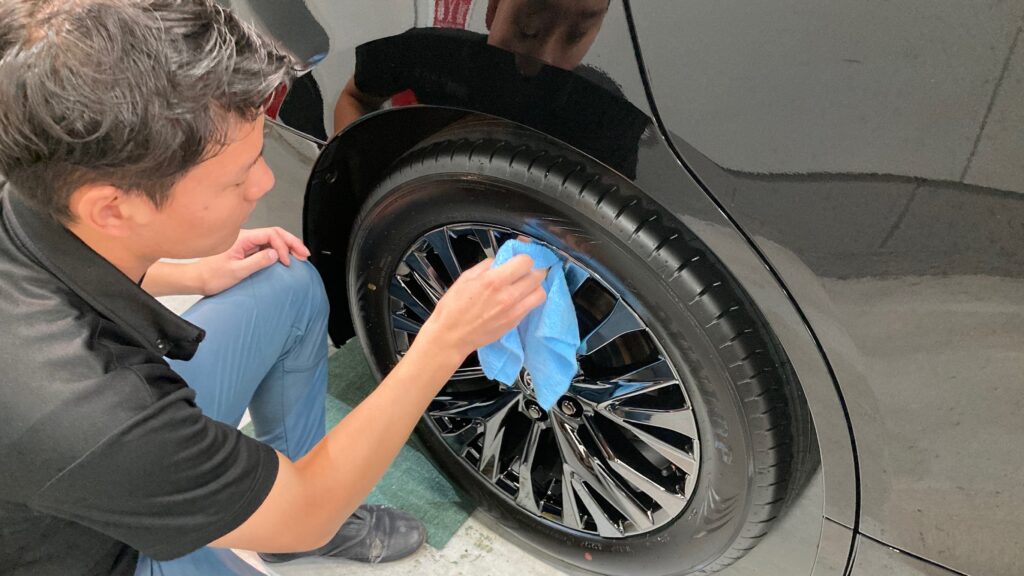 トヨタ・新型ヴェルファイア：クラスM施工：仕上げ作業工程：ホイールを拭き上げている様子