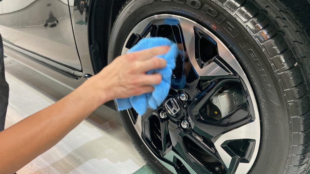 ホンダ・Ｎ－ＷＧＮ：クラスＭ施工：仕上げ作業工程：ホイールを拭きあげている様子