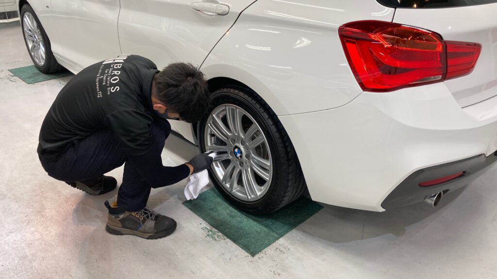 BMW・１シリーズ：クラスM施工：仕上げ作業工程：ホイールを拭きあげている様子