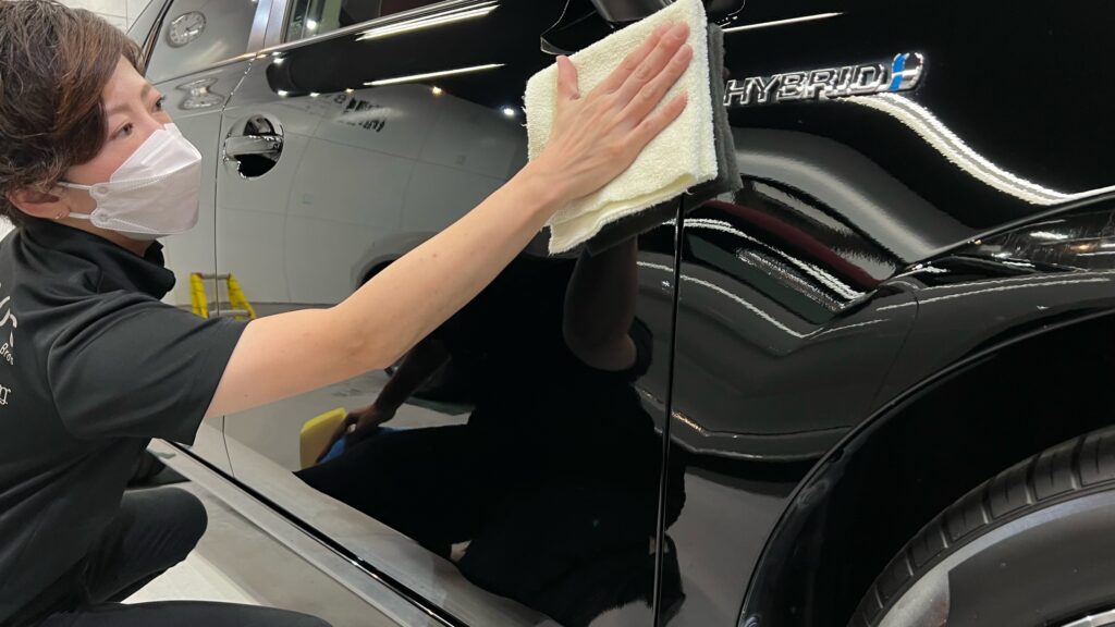 トヨタ・プリウスα：クラスM施工：仕上げ作業工程：コーティング剤を塗布後、レベリングしている様子