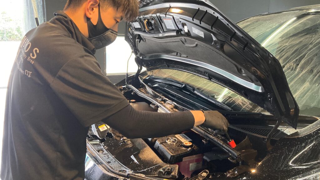 トヨタ・アルファード：アドバンスド施工：下地処理工程：エンジンルームを洗浄している様子
