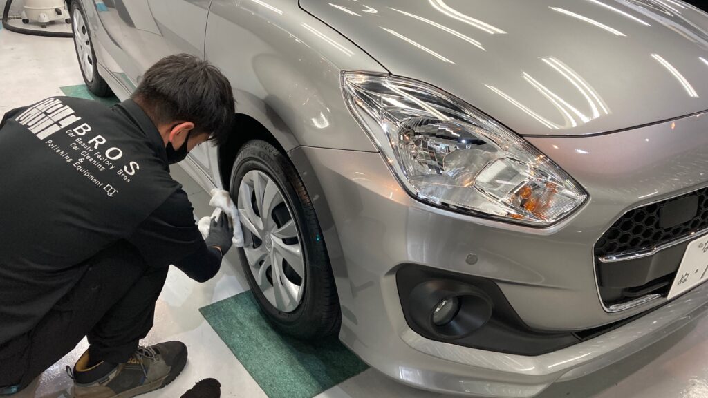 スズキ・スイフト：クラスM施工：仕上げ作業工程：ホイールを拭きあげている様子