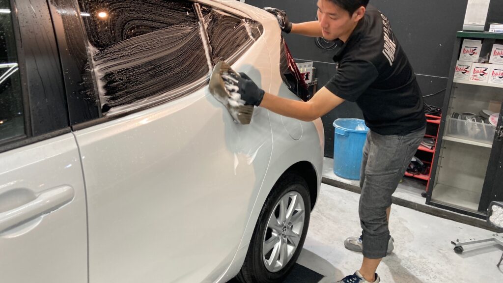 トヨタ・アクア：グラフェンアドバンスド施工：下地処理工程：ボディを洗車している様子