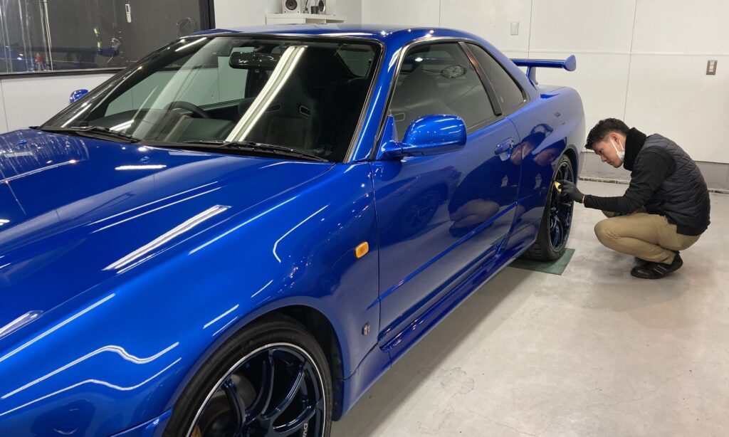 日産・R34GT-R：クラスM施工：仕上げ作業工程：ホイールにコーティング剤を塗布、レベリングしている様子
