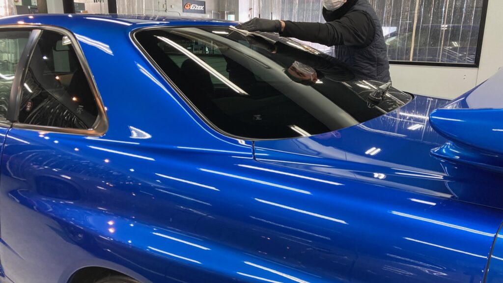 日産・R34GT-R：クラスM施工：仕上げ作業工程：ウィンドウ撥水を施工したいる様子
