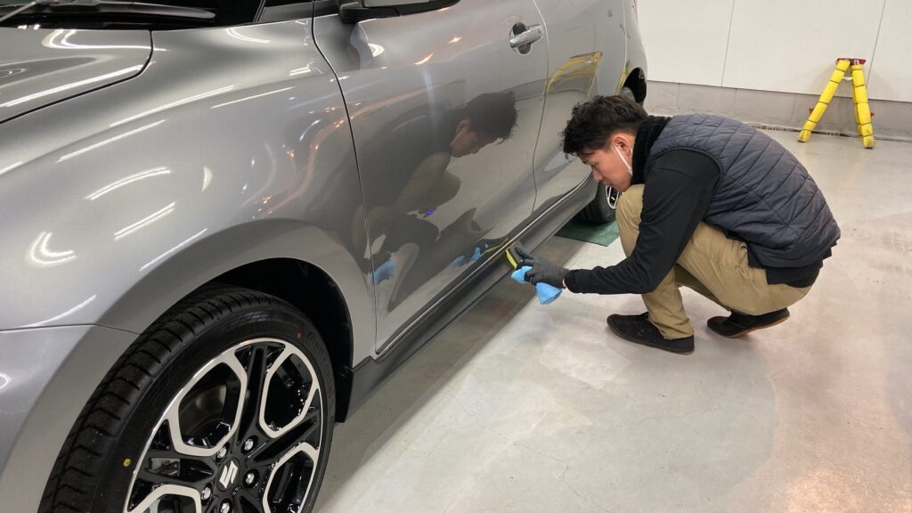 スズキ・スイフトスポーツ：クラスM施工：仕上げ作業工程：樹脂パーツにコーティング剤を塗布しレベリングしている様子