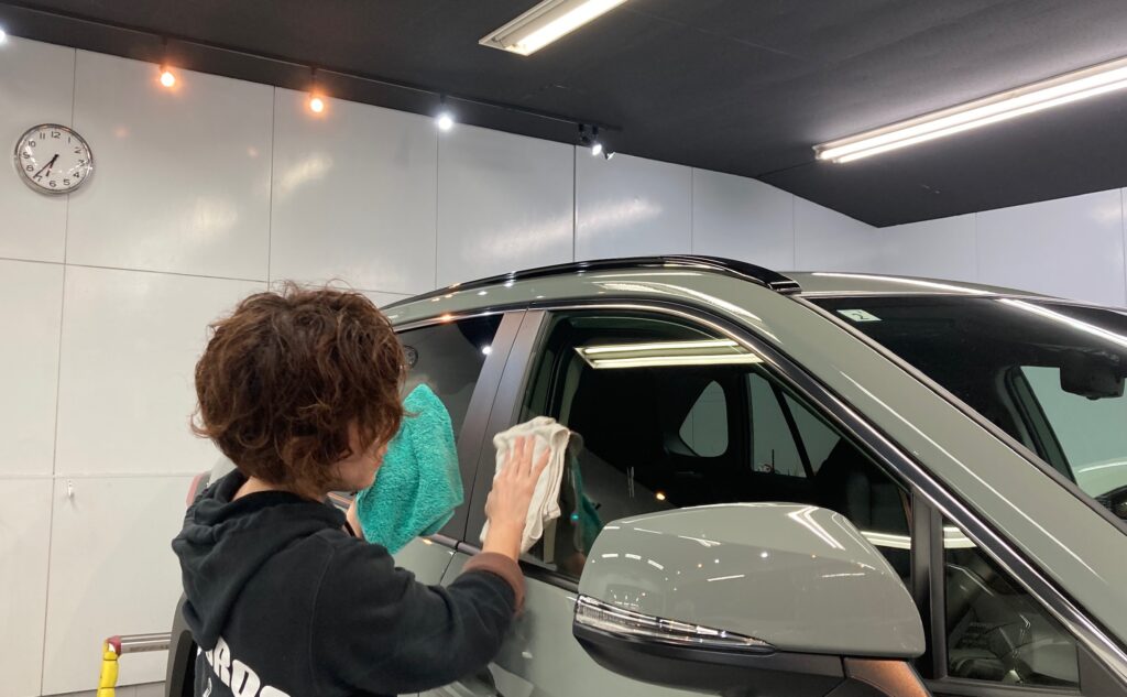 トヨタ・RAV4：クラスM施工：仕上げ作業工程：窓を拭き、最終チェックをしている様子