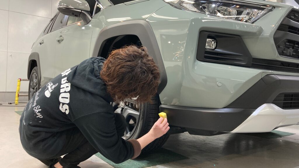 トヨタ・RAV4：クラスM施工：仕上げ作業工程：樹脂パーツにコーティング剤を塗布しレベリングしている様子
