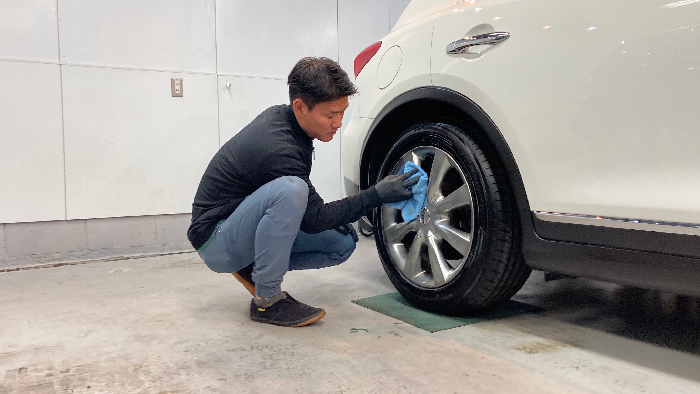 日産・スカイライン：クラスＭ施工：仕上げ作業工程：ホイールを拭き上げている様子